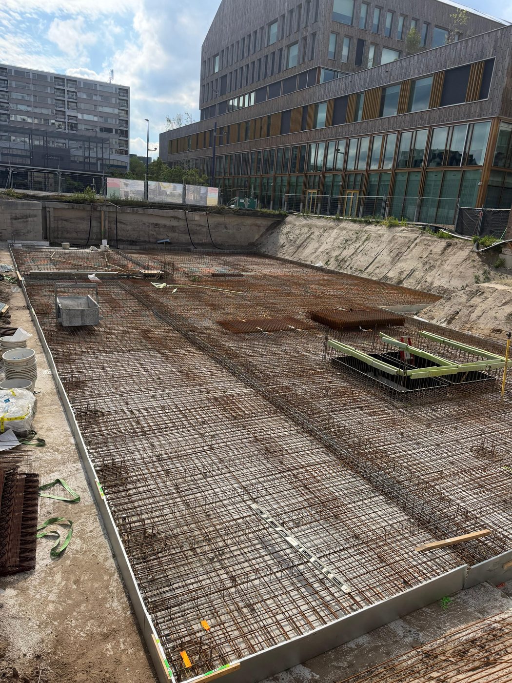 Gewapende vloer in de verdiepte bouwkuip, met de aangrenzende kantoorbebouwing