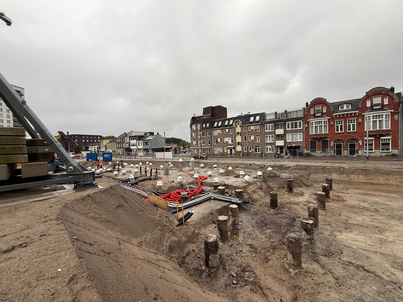 Paalkoppen in de uitgegraven bouwput, klaar voor het vlechten van de poeren