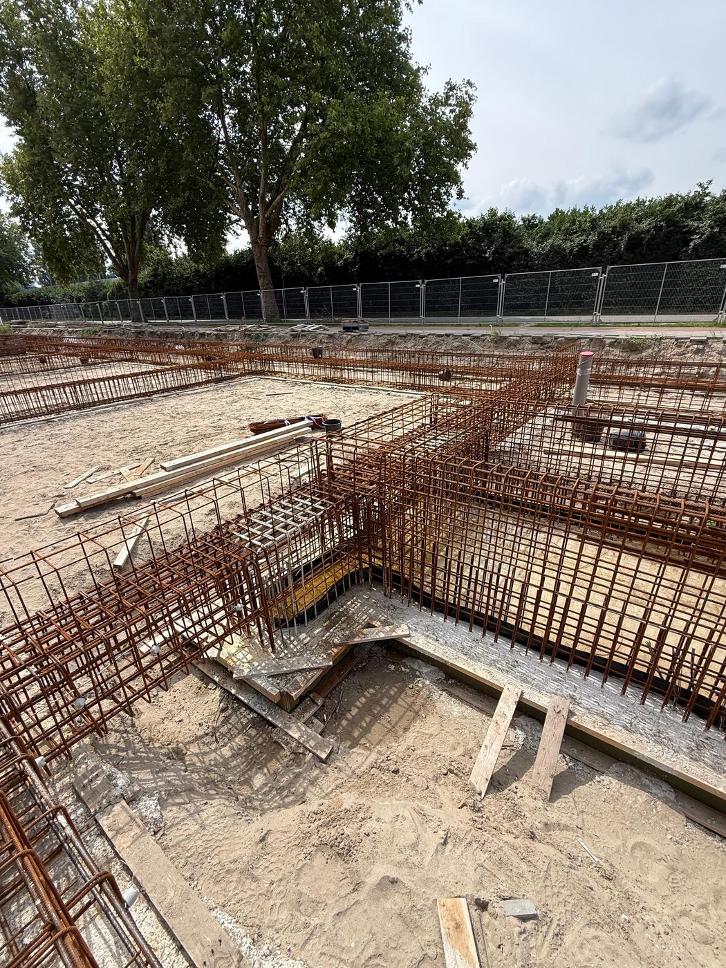 Funderingsbalken met wapening rond een verdiepte sleuf op de werkvloer