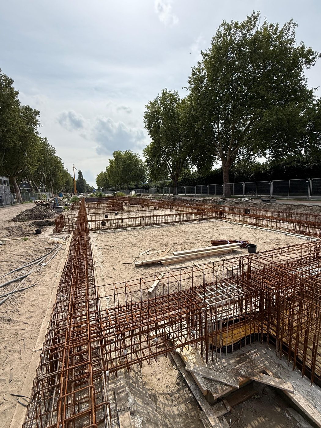 Wapening van een funderingsbalk, met de bomenrij langs de Oost-Sidelinge op de achtergrond