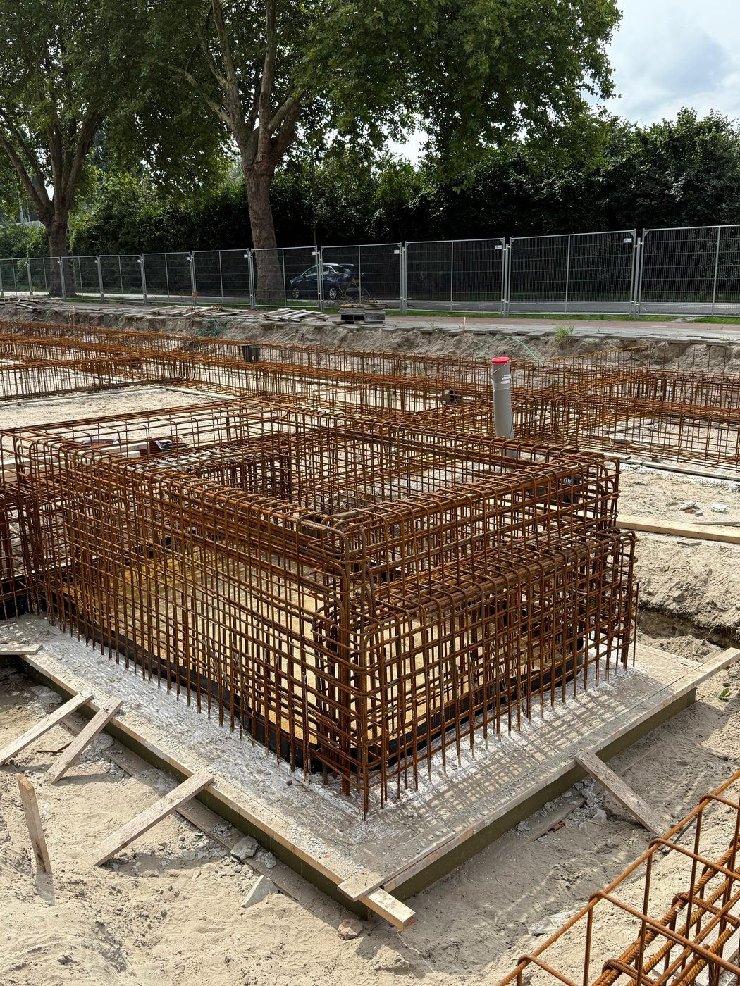 Hoog opgebouwde wapeningskorf voor een poer, op de werkvloer tussen de funderingsbalken