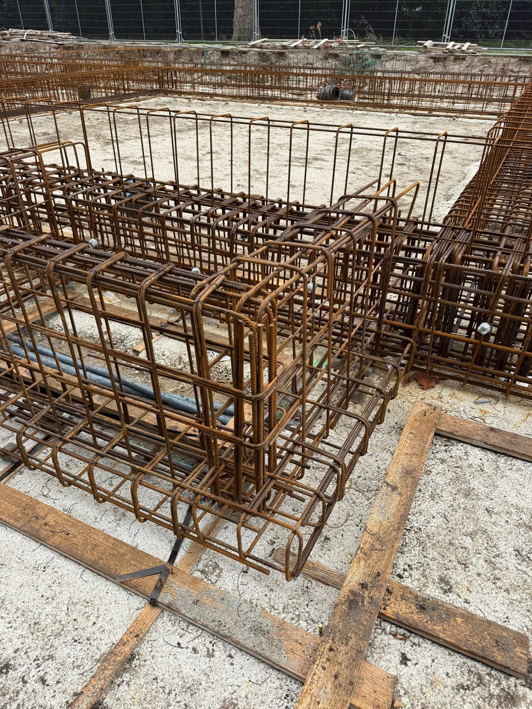 Detail van een wapeningskorf met de blauwe mantelbuizen van de installateur ernaast