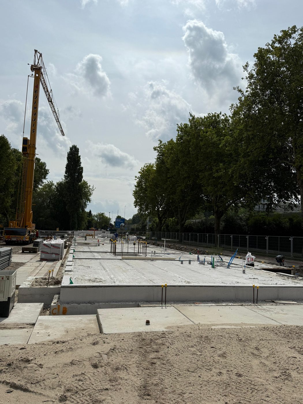 Mobiele kraan legt de prefab vloerplaten op de gestorte fundering